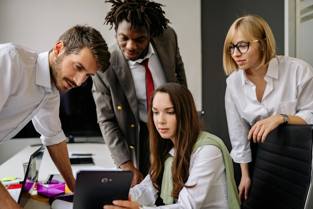 Colleagues discussing work around a laptop